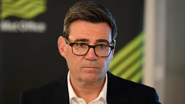 Andy Burnham, a man wearing glasses.