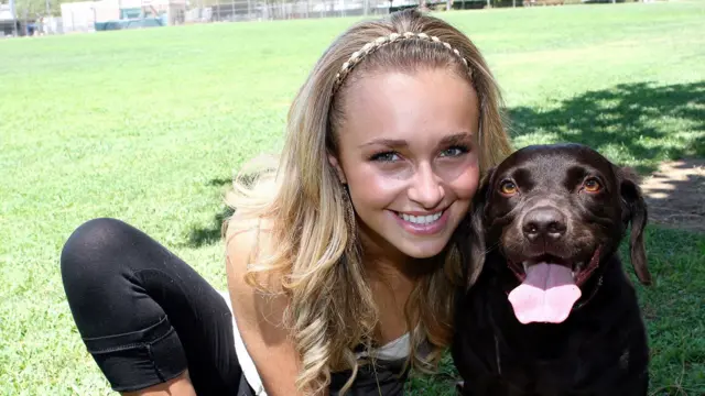 Hayden Panettiere, wearing a headband and smiling, poses for a portrait with her pet dog Penny Lane during a photo shoot at La Cienega Park in Beverly Hills, CA on July 22, 2006.