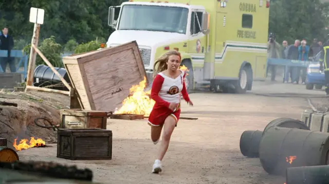 Hayden Panettiere starring as Claire Benet in Heroes as she runs past tyres that are on fire