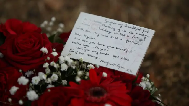 A message inside a floral tribute is pictured.