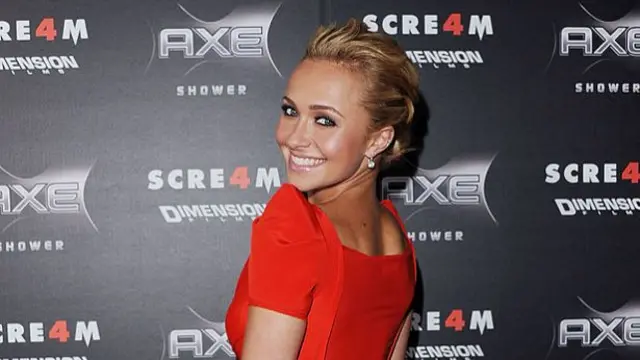 Hayden Panettiere smiling and looking over her shoulder at the Scream 4 premier, where she is wearing a red dress