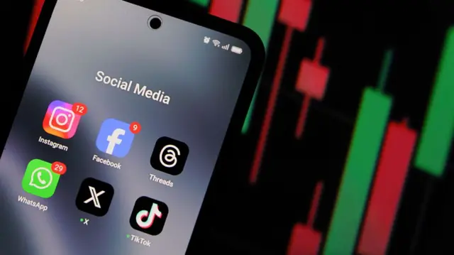 A picture of an iPhone with apps on the home screen, including Instagram, Facebook, Threads, WhatsApp, X and TikTok