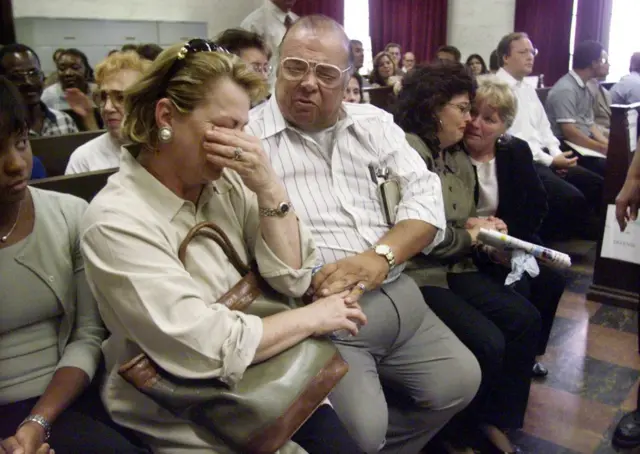 Lead plaintiff Guillermo Saa (C) reacts to the decision reached by a jury in the first class action suit against the tobacco industry in a Miami courtroom in 1999