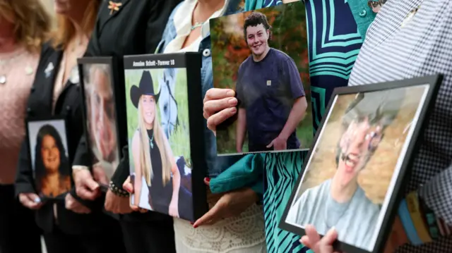 People hold pictures of children and young adults, as parents of children whose deaths were related to social media