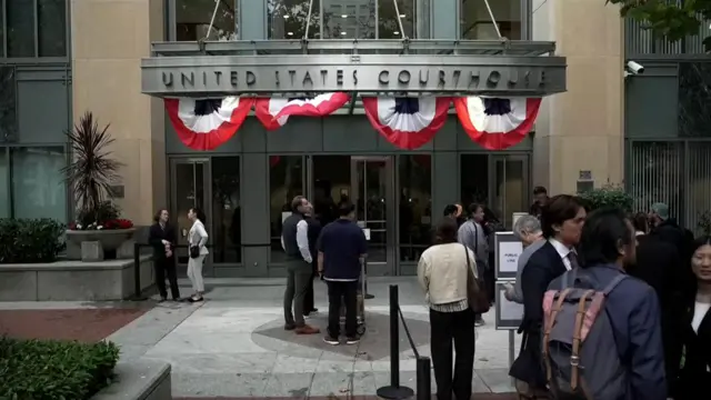 People queue outside the courtroom. A sign reads "United States Courthouse"