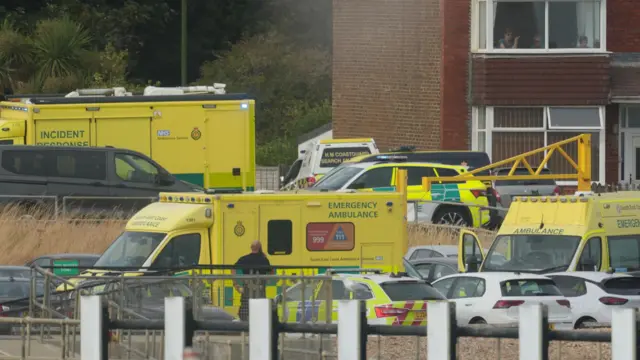 Emergency response vehicles, ambulances, a coastguard vehicle and police vehicles are parked near homes close to Shoreham Port.