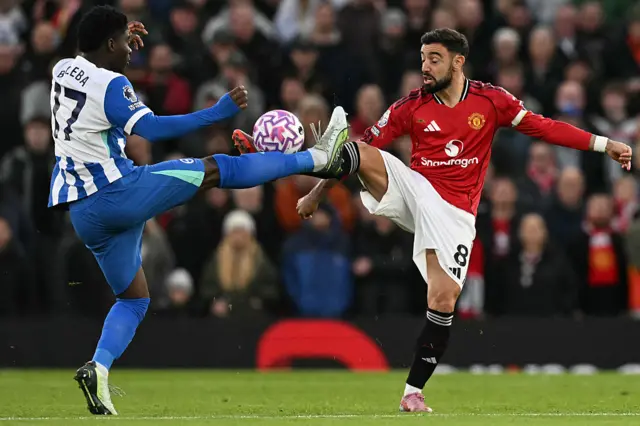 Manchester United's Portuguese midfielder #08 Bruno Fernandes (R) and Brighton's Cameroonian midfielder #17 Carlos Baleba (L) battle for the ball