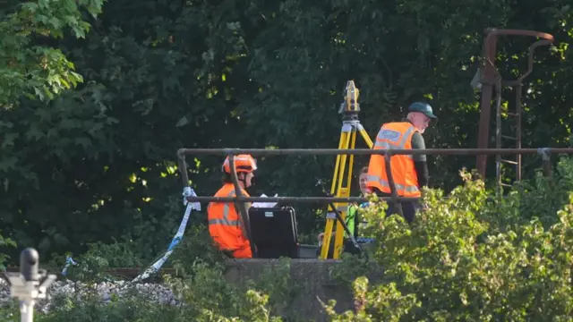 Two emergency workers sat in hi vis with equipment next to them