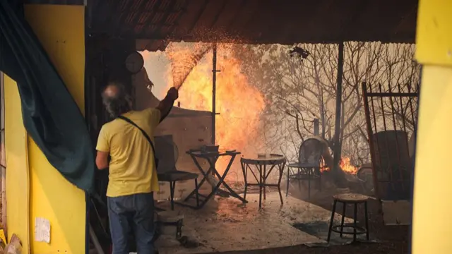 Man trying to extinguish flames coming into his home
