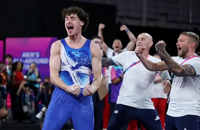 Gold medalist Reuben Ward of Team Scotland celebrates victory with teammates after the Men's All-Around Final