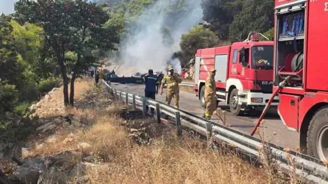 Firefighters work at the site where firefighting helicopters crashed, during a fire in the wider region of Megara, West Attica, Greece