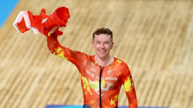 Matthew Bostock waves the Isle of Man flag after winning Commonwealth gold
