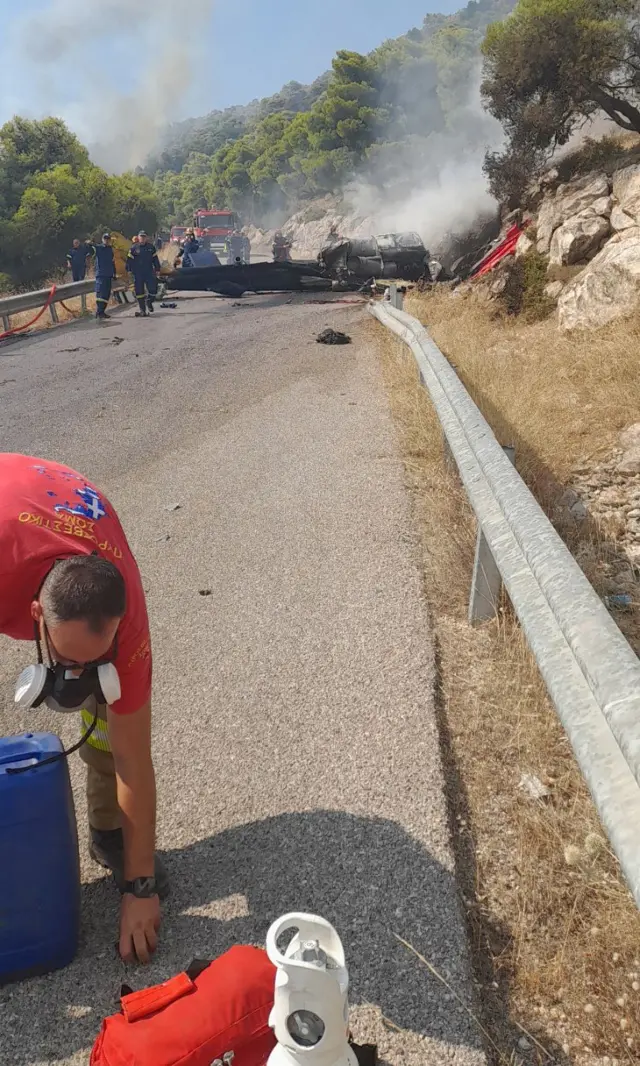 Firefighters work at the site where firefighting helicopters crashed during a fire in the wider region of Megara, West Attica, Greece