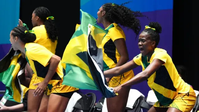 Jamaica's netballers celebrate with a flag