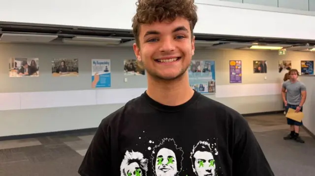 Jack in his school with short brown hair wearing a Green Day band tshirt