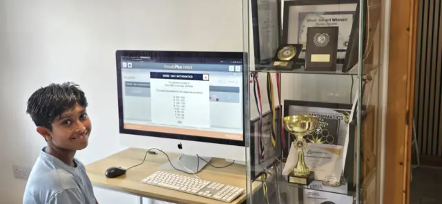 Kabir smiles at his computer after receiving his result online