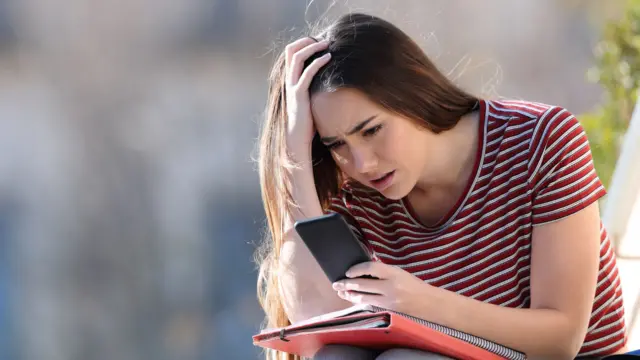 A worried student checks her results