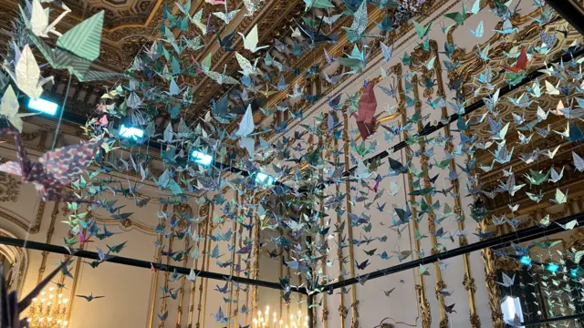 Paper cranes in a line down from the ceiling