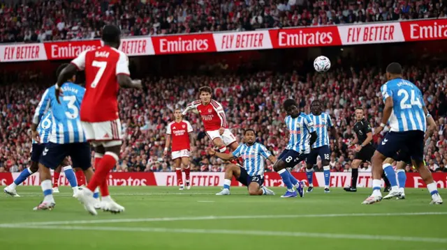 Christos Tzolis of Arsenal shoots under pressure from Milan van Ewijk of Coventry City during the Premier League 2026/27 match between Arsenal FC and Coventry City at Emirates Stadium.
