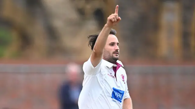 Lewis Gregory has his arm raised after taking the wicket of Dean Elgar