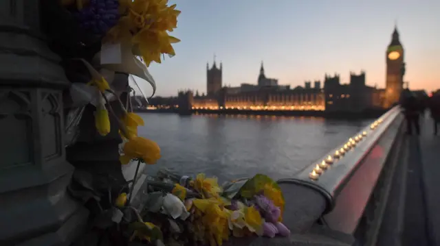 Dusk on Westminster bridge after the 2017 terror attack. Candles are lined up along the wall and the Houses of Parliament are in the background