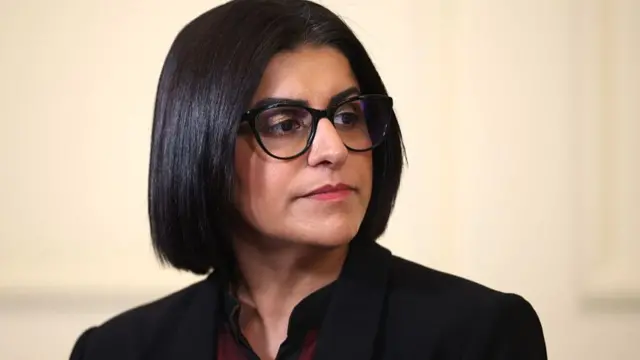 Home Secretary Shabana Mahmood is pictured with a serious expression on her face, looking off camera.