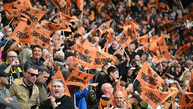 Hull City's fans wave their free flags ahead of kick off in the English Premier League football match between Hull City and Manchester United at the MKM Stadium.