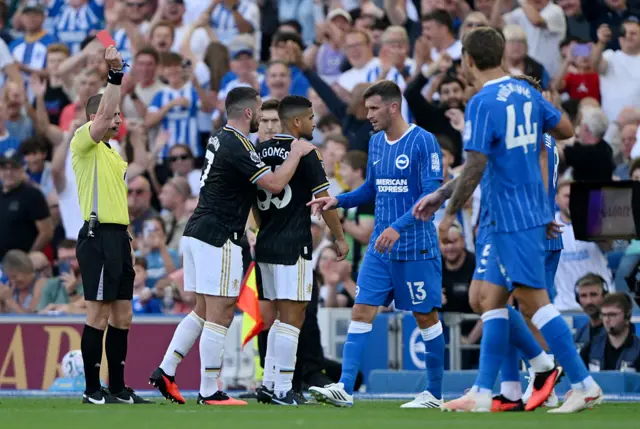 Joao Gomes of Aston Villa receives a red card by referee Peter Bankes during the Premier League 2026/27 match between Brighton & Hove Albion and Aston Villa FC at American Express Stadium.