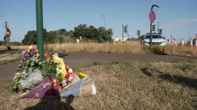 flowers placed at the base of a sign.