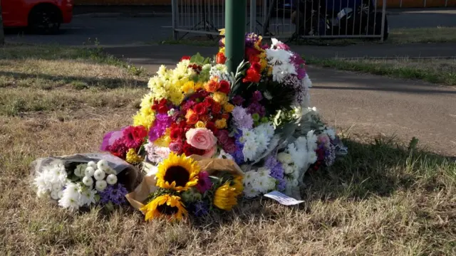 flowers placed at base of sign