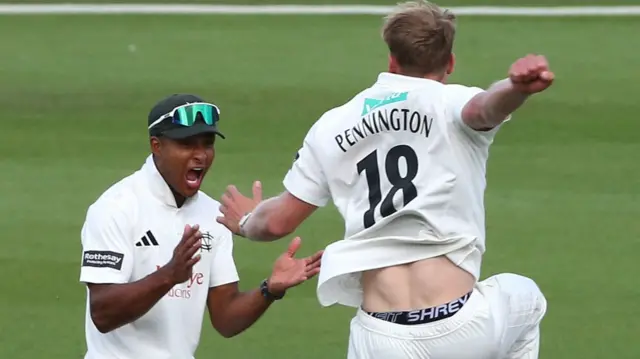 Dillon Pennington (right) jumping for joy after taking a wicket as he celebrates with Ben Martindale