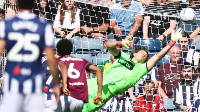 Action shot as ball flies into net past diving Burnley goalkeeper Max Weiss