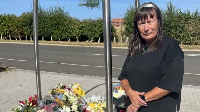 Gill Elgie, a woman with medium length brown hair, stands at the police memorial garden at Cleveland Police Central HQ