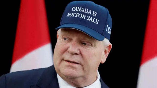 A close up shot of Doug Ford, who wears a hat saying Canada is not for sale