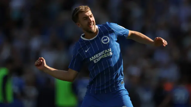 Jack Hinshelwood celebrating a goal. He is wearing a blue Brighton home kit.
