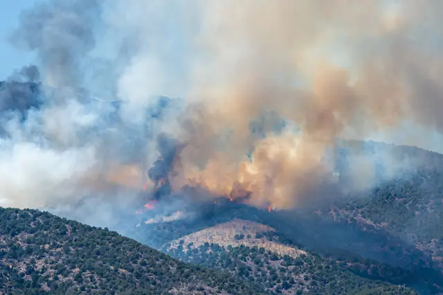 Large plumes of smoke and fire coming from the mountains