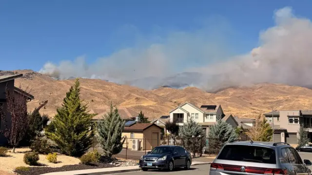 Smoke rises in the hills in Nevada near homes