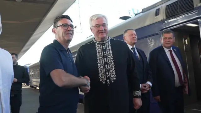 Andy Burnham shaking hands with Ukraine's foreign minister next to a train