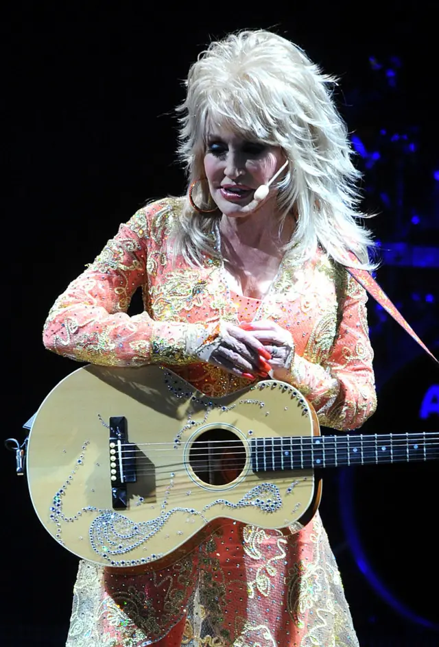 Dolly Parton and her guitar on stage