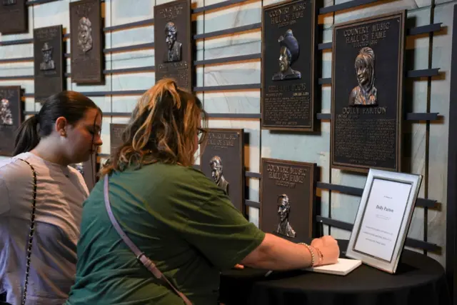 People gather at the Country Music Hall of Fame after it was announced that country music icon Dolly Parton died aged 80, in Nashville, Tennessee, U.S., August 25, 2026.