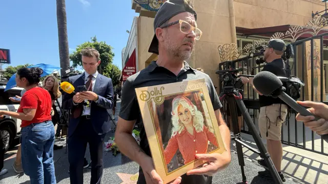 ChadMichael Morrissette holds a Dolly Parton album, All I Can Do