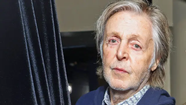 Headshot of musician Paul McCartney, wearing blue blazer and open-necked shirt, taken in 2023