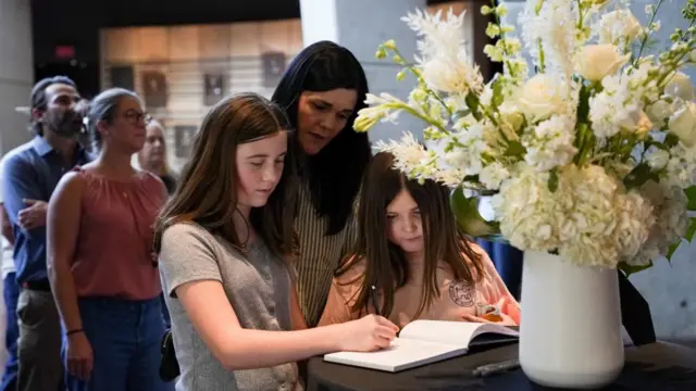 People gather at the Country Music Hall of Fame to sign a guest book in memory of Dolly Parton