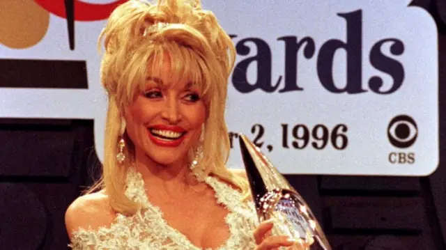 Dolly Parton with her Country Music Award for her version of "I Will Always Love You" she recorded with Vince-Gill