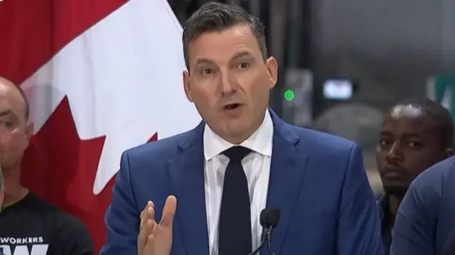 Evan Solomon speaking at a podium