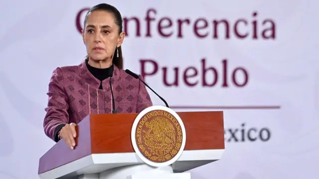 President of Mexico Claudia Sheinbaum speaking into a microphone behind a podium.