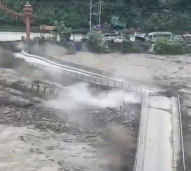 Screenshot of a video showing debris from a bridge smashing another bridge in two