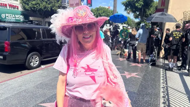 Dolly Parton superfan wearing all pink with her dog at the Hollywood Walk of Fame