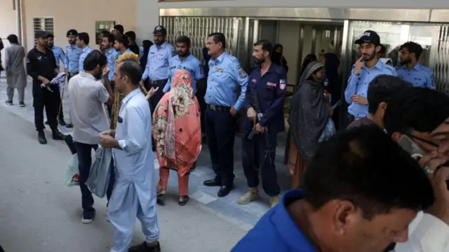 Families gather outside the hospital in Islamabad where the fire took place in the maternity unit