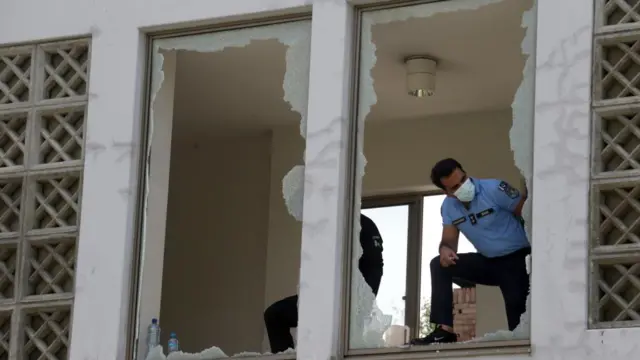 Officials examine smashed windows at the Islamabad hospital where a fire claimed the lives of at least 14 new-born babies